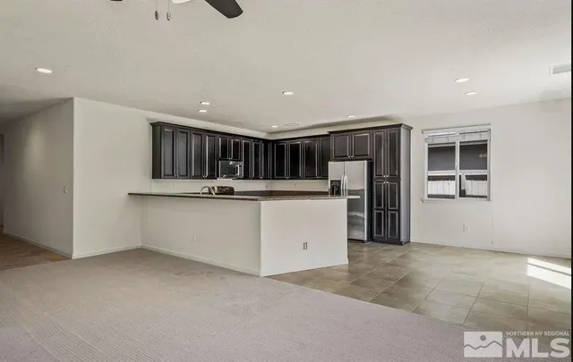 a view of kitchen with refrigerator and white cabinets