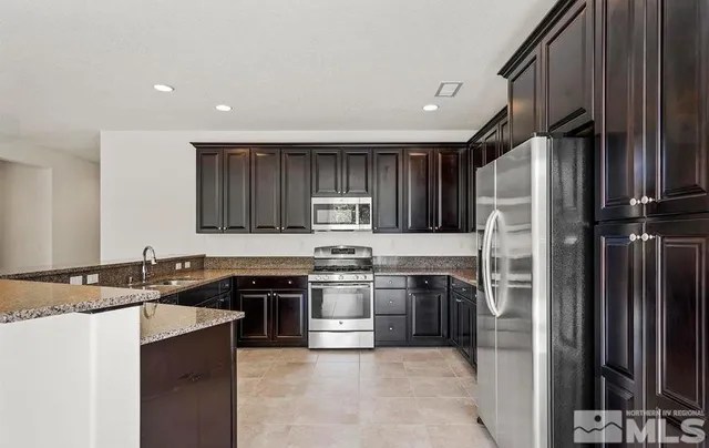 a kitchen with stainless steel appliances granite countertop a refrigerator stove a sink and dishwasher