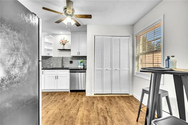 a kitchen with granite countertop a refrigerator and a stove top oven
