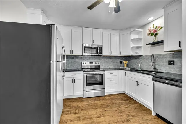 a kitchen with granite countertop white cabinets and white appliances
