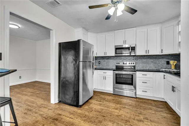 a kitchen with stainless steel appliances a refrigerator sink and cabinets