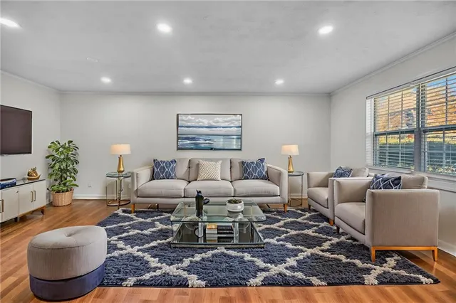 a living room with furniture wooden floor and a large window