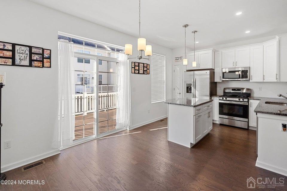 304 Discovery Road, Unit 1804 Brick, NJ 08723 - Photo 12 of 48 a kitchen with stainless steel appliances granite countertop a refrigerator a stove oven a sink dishwasher and white cabinets with wooden floor