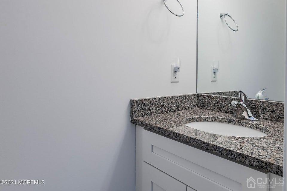 304 Discovery Road, Unit 1804 Brick, NJ 08723 - Photo 13 of 48 a bathroom with a granite countertop sink and a mirror