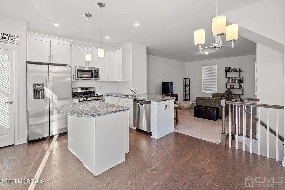 304 Discovery Road, Unit 1804 Brick, NJ 08723 - Photo 14 of 48 a kitchen with stainless steel appliances kitchen island a refrigerator sink and cabinets