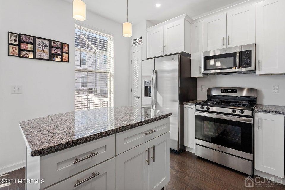 304 Discovery Road, Unit 1804 Brick, NJ 08723 - Photo 17 of 48 a kitchen with stainless steel appliances granite countertop a stove a refrigerator and a microwave