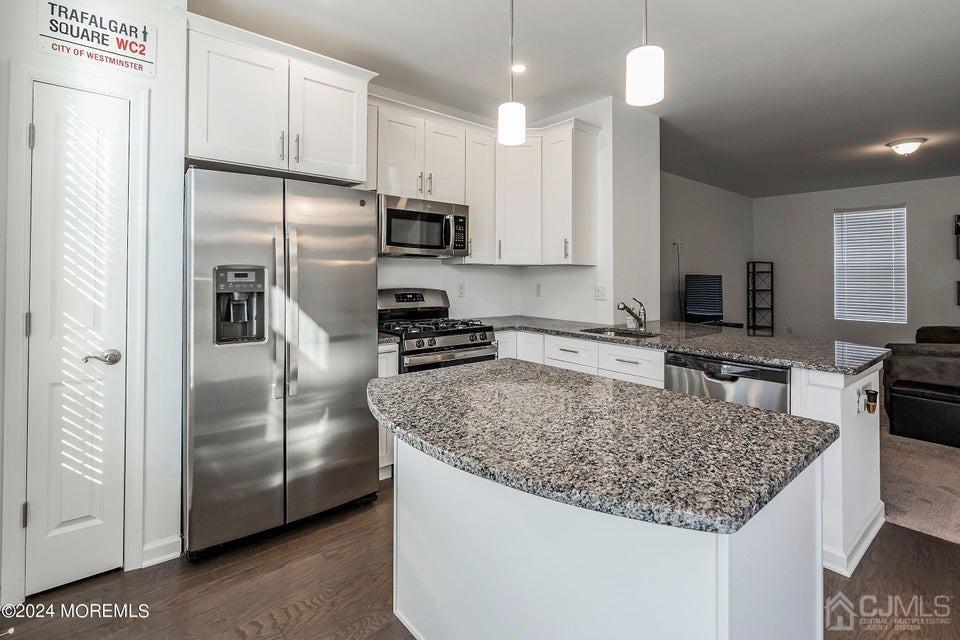 304 Discovery Road, Unit 1804 Brick, NJ 08723 - Photo 18 of 48 a kitchen with stainless steel appliances granite countertop a refrigerator a stove a sink and a refrigerator
