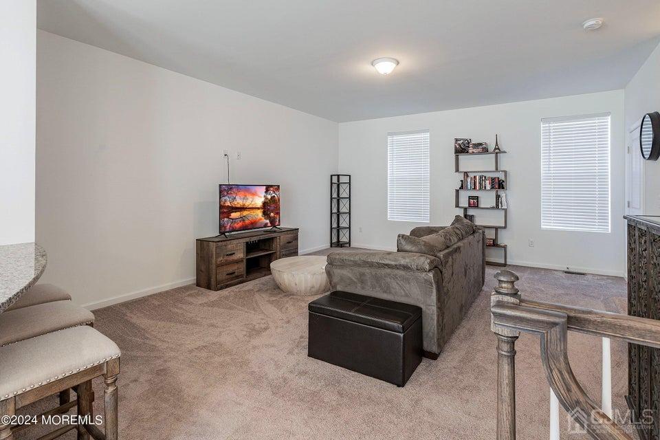304 Discovery Road, Unit 1804 Brick, NJ 08723 - Photo 19 of 48 a living room with furniture and a flat screen tv