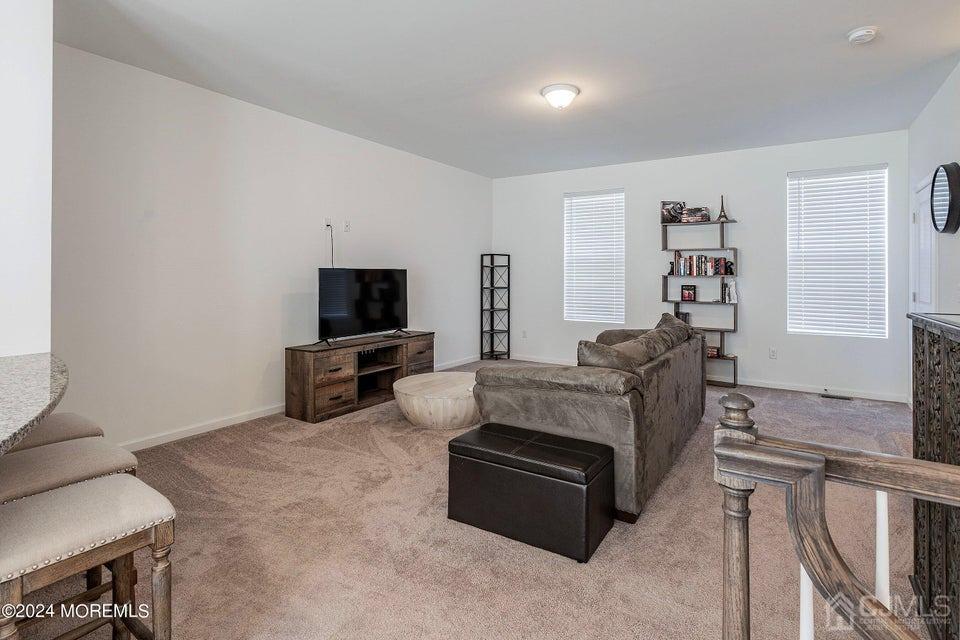 304 Discovery Road, Unit 1804 Brick, NJ 08723 - Photo 20 of 48 a living room with furniture and a flat screen tv
