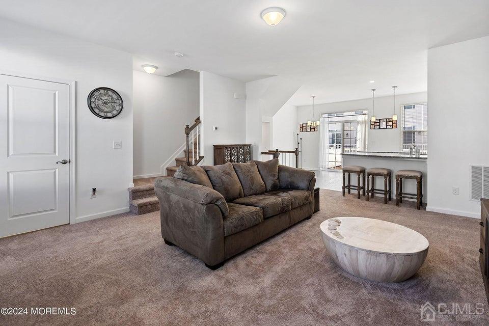 304 Discovery Road, Unit 1804 Brick, NJ 08723 - Photo 24 of 48 a living room with furniture a table and kitchen view