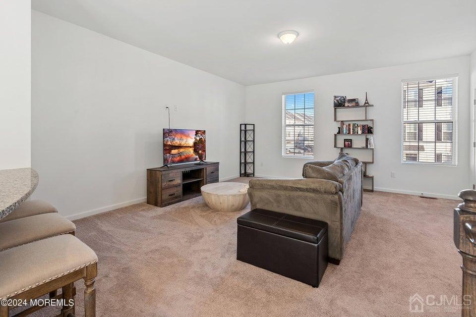 304 Discovery Road, Unit 1804 Brick, NJ 08723 - Photo 25 of 48 a living room with furniture and a flat screen tv