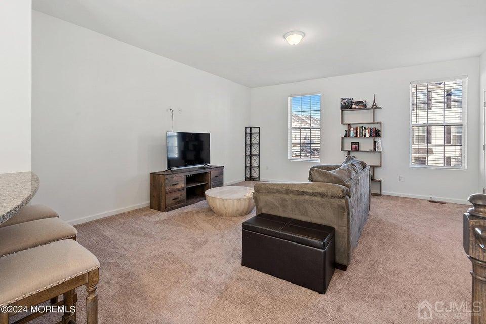 304 Discovery Road, Unit 1804 Brick, NJ 08723 - Photo 26 of 48 a living room with furniture and a flat screen tv