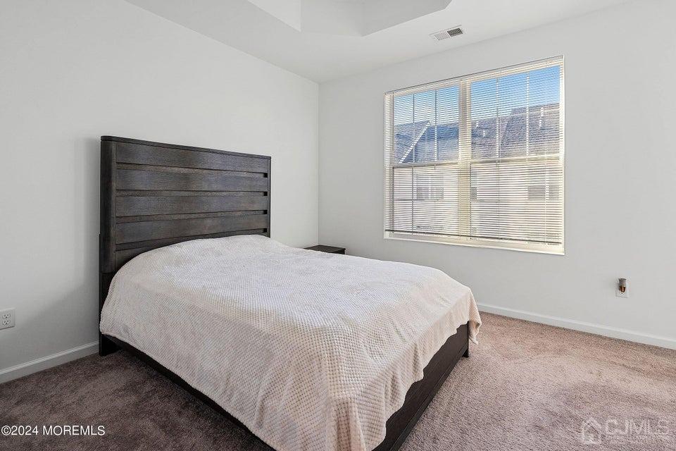 304 Discovery Road, Unit 1804 Brick, NJ 08723 - Photo 27 of 48 a bed sitting in a bedroom next to a window