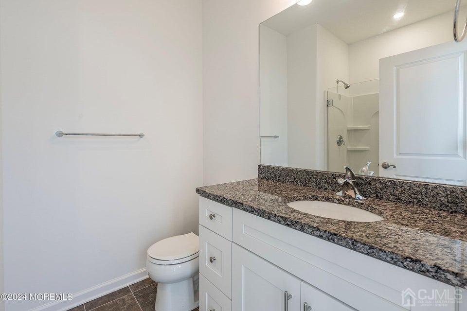 304 Discovery Road, Unit 1804 Brick, NJ 08723 - Photo 30 of 48 a bathroom with a granite countertop toilet sink and mirror