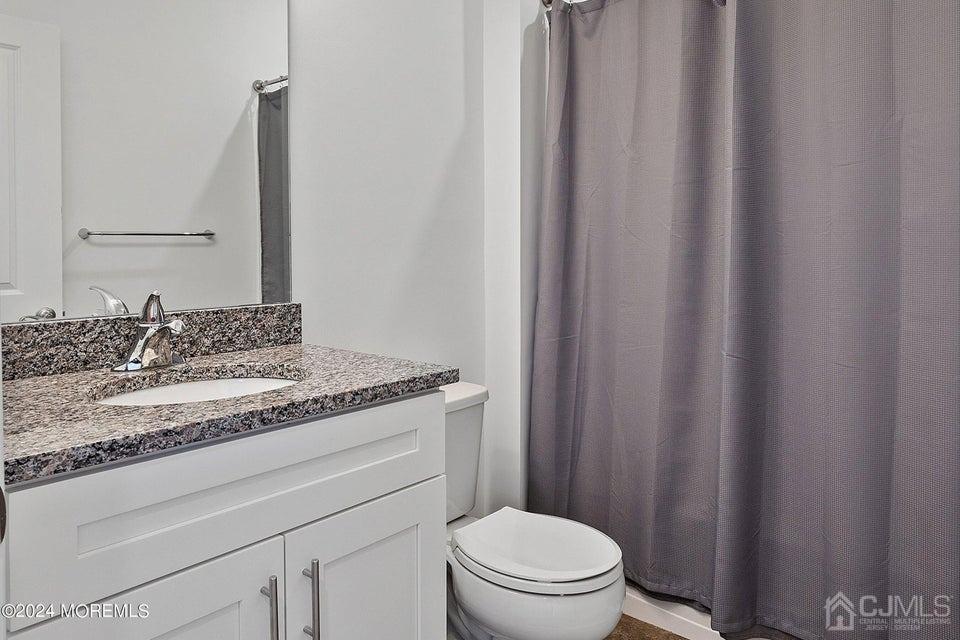 304 Discovery Road, Unit 1804 Brick, NJ 08723 - Photo 34 of 48 a bathroom with a granite countertop sink toilet and a mirror