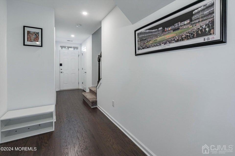304 Discovery Road, Unit 1804 Brick, NJ 08723 - Photo 35 of 48 a view of a hallway with wooden floor and a bookshelf