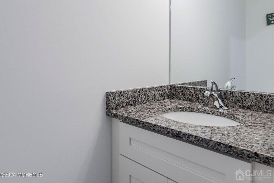 304 Discovery Road, Unit 1804 Brick, NJ 08723 - Photo 36 of 48 a bathroom with a granite countertop sink and a mirror