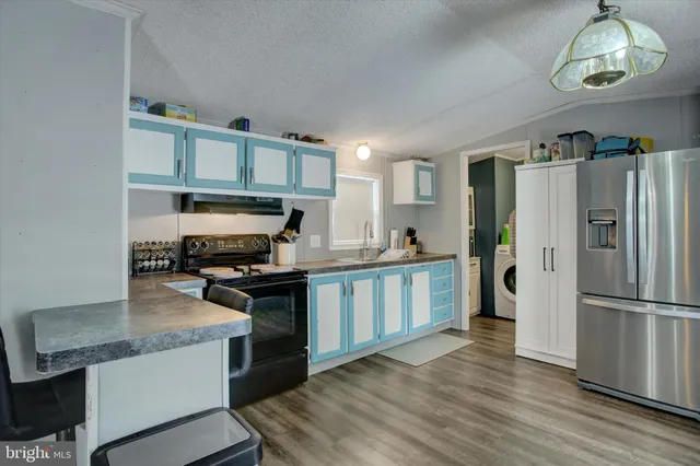 a kitchen with stainless steel appliances granite countertop a stove refrigerator and a sink