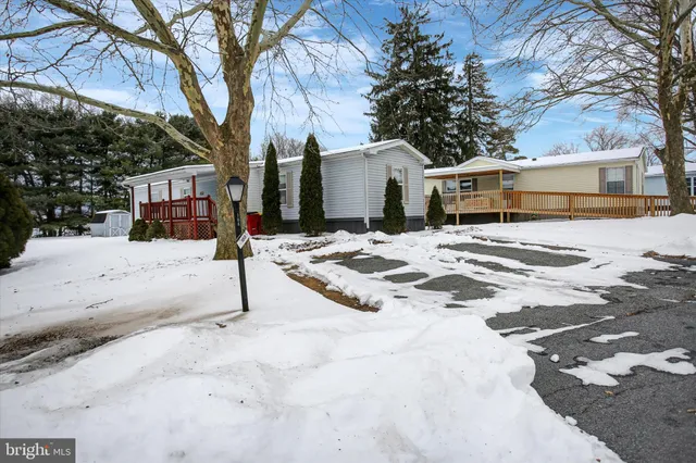 a view of a white house with a yard covered in snow