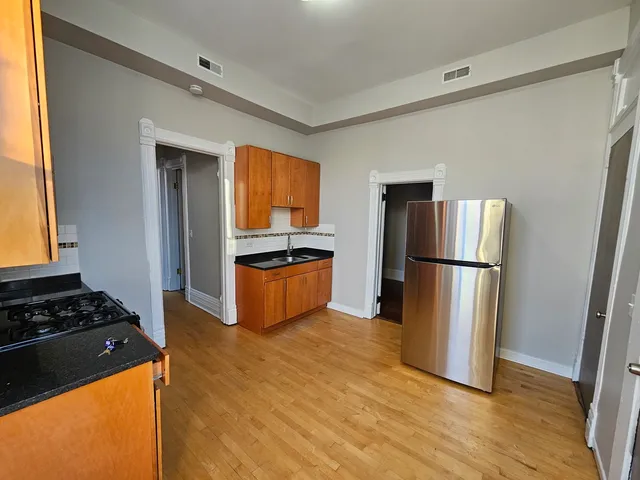 a kitchen with a refrigerator a stove top oven a sink and a window