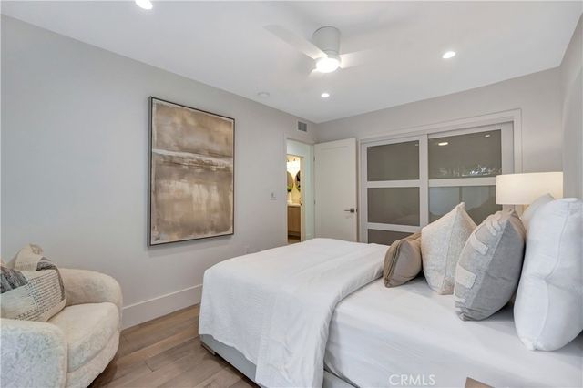 a bed sitting in a spacious bedroom next to a window