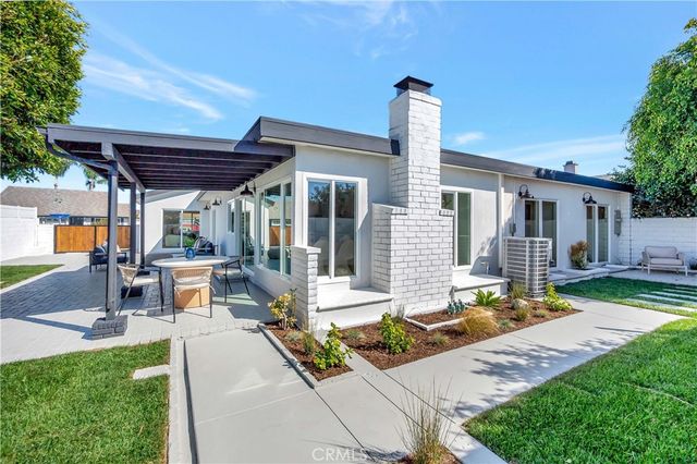 a view of a house with backyard and sitting area