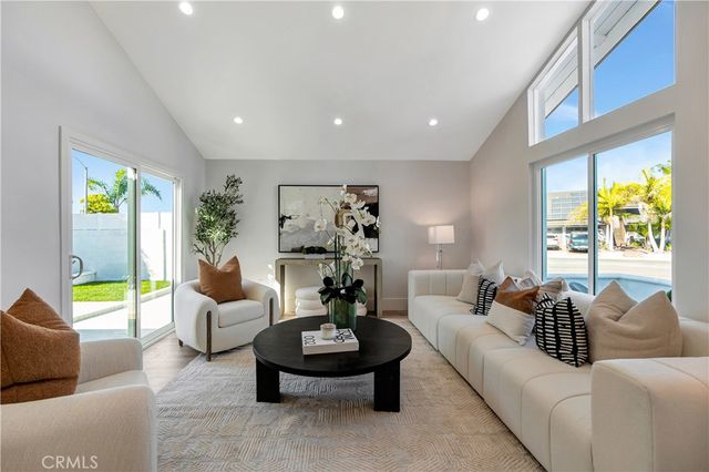 a large room with stainless steel appliances kitchen island granite countertop wooden floors and white cabinets