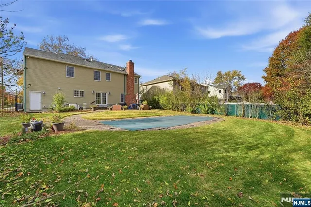 a view of swimming pool with outdoor seating and house in the background