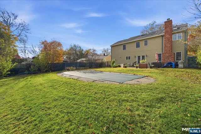 a backyard of a house with lots of green space and fountain