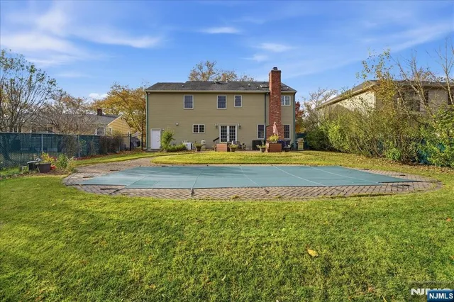 a view of a house with a swimming pool and a yard