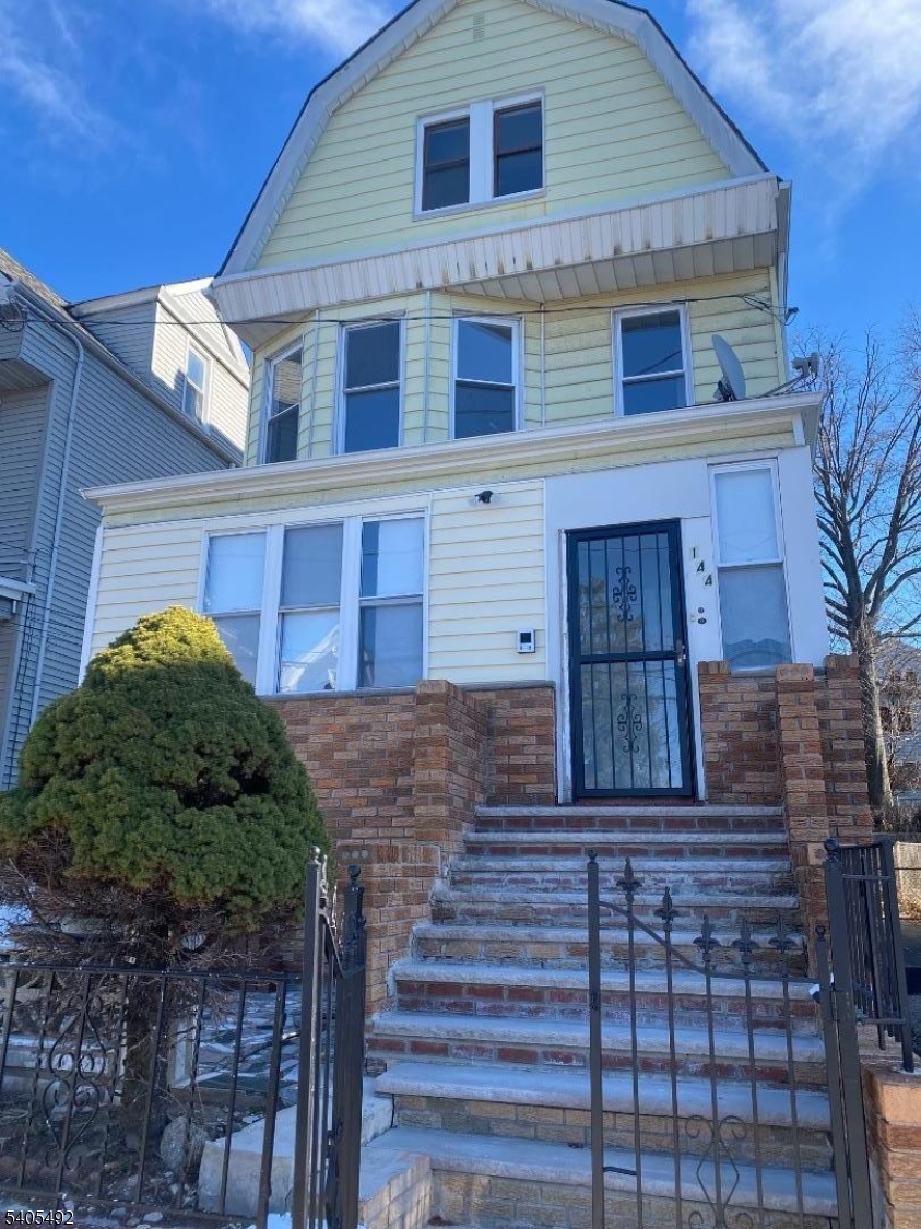 144 Maple Avenue Irvington, NJ 07111 - Photo 2 of 12 a front view of a house with plants and large windows