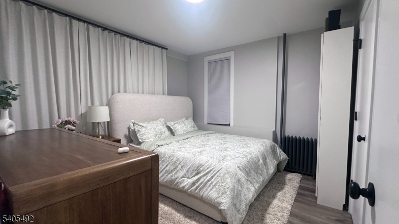 144 Maple Avenue Irvington, NJ 07111 - Photo 3 of 12 a bed sitting in a bedroom next to a window