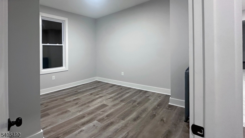 144 Maple Avenue Irvington, NJ 07111 - Photo 7 of 12 a view of an empty room with wooden floor and a window
