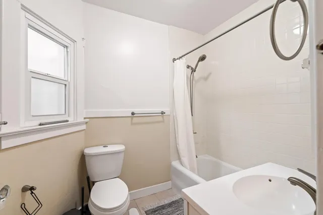 a white toilet sitting next to a bathroom sink and a tub