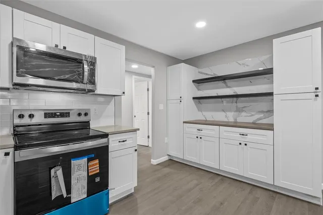 a kitchen with white cabinets and stainless steel appliances
