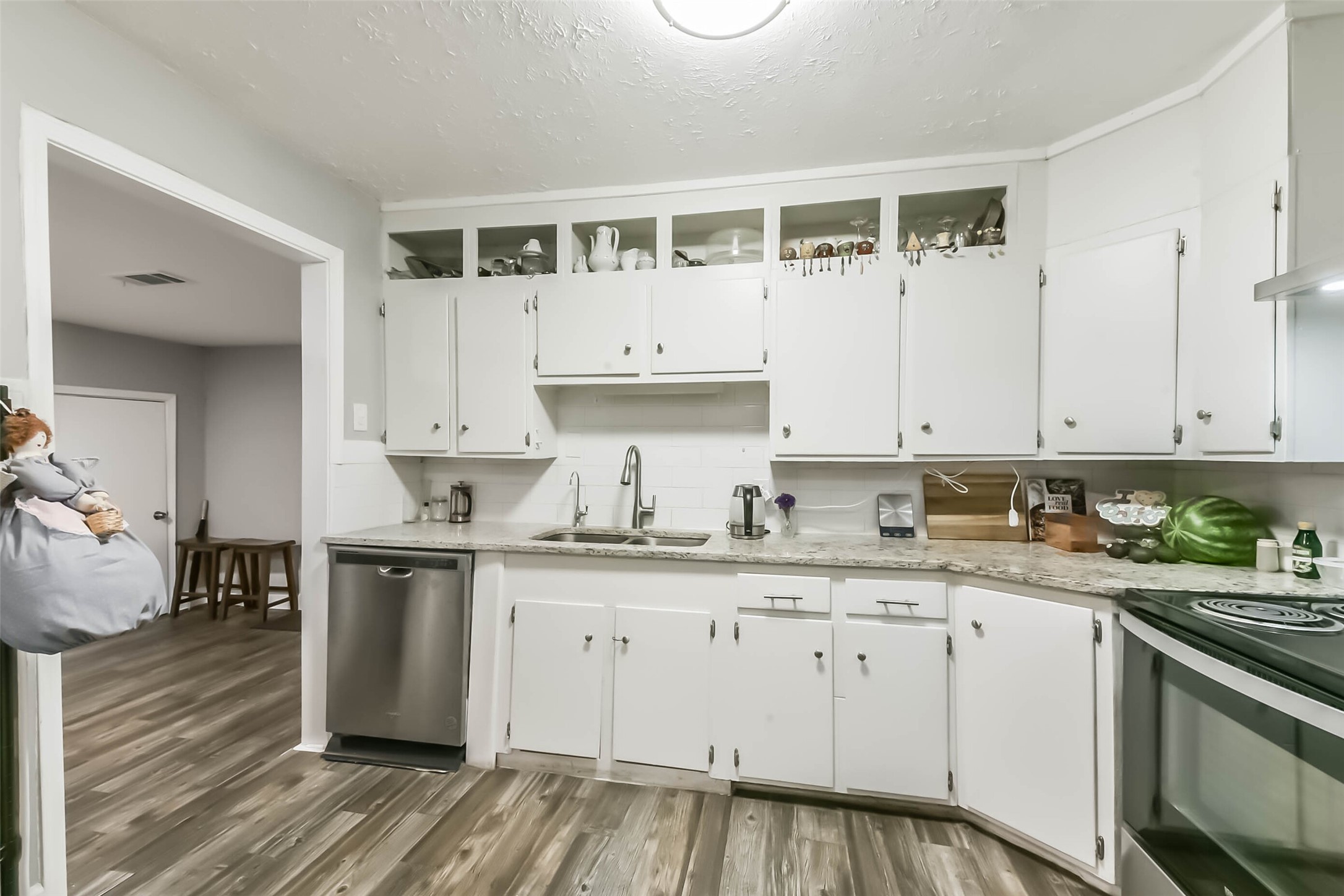 1102 West Hart Avenue Pasadena, TX 77506 - Photo 22 of 40 a kitchen with granite countertop white cabinets and white appliances