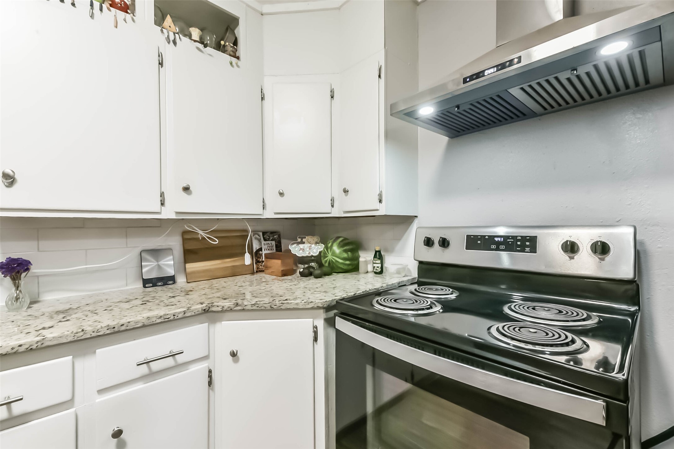 1102 West Hart Avenue Pasadena, TX 77506 - Photo 23 of 40 a kitchen with granite countertop a stove and a white cabinets