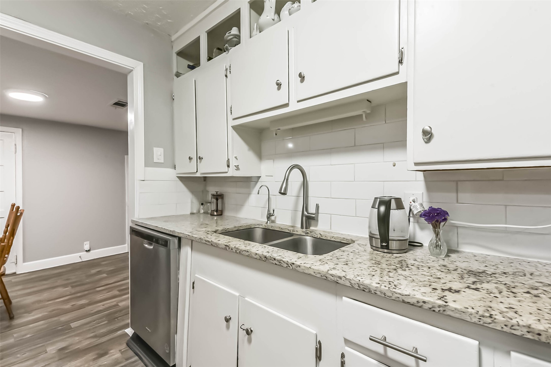 1102 West Hart Avenue Pasadena, TX 77506 - Photo 24 of 40 a kitchen with stainless steel appliances granite countertop a sink a stove and white cabinets with wooden floor