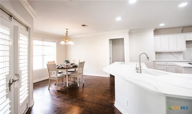 a kitchen with stainless steel appliances kitchen island granite countertop a refrigerator and a stove top oven