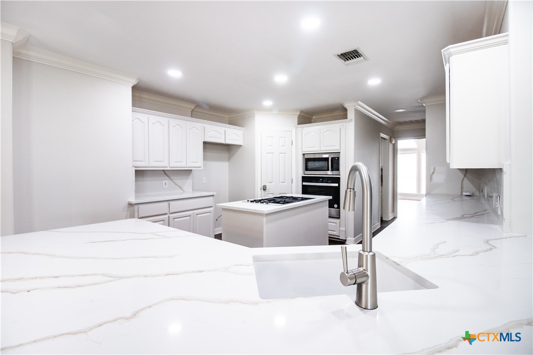 202 Ridge View Victoria, TX 77904 - Photo 17 of 41 a kitchen with stainless steel appliances kitchen island granite countertop a refrigerator and a stove top oven