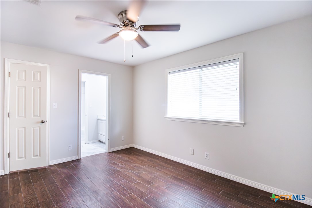 202 Ridge View Victoria, TX 77904 - Photo 33 of 41 an empty room with wooden floor ceiling fan and windows