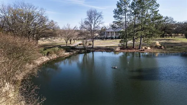 a view of residential houses with lake and trees