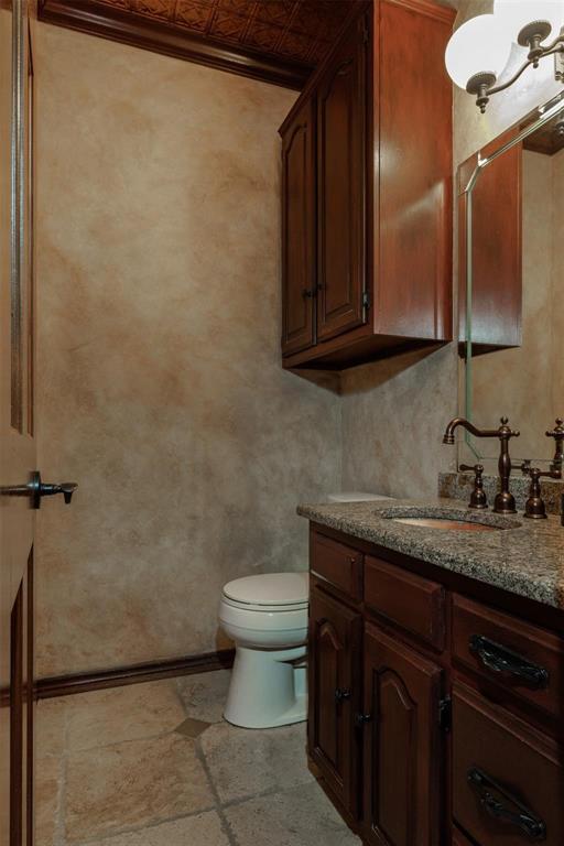 6569 Fm 2947, Unit 4 Quinlan, TX 75474 - Photo 23 of 37 a bathroom with a granite countertop sink toilet and mirror
