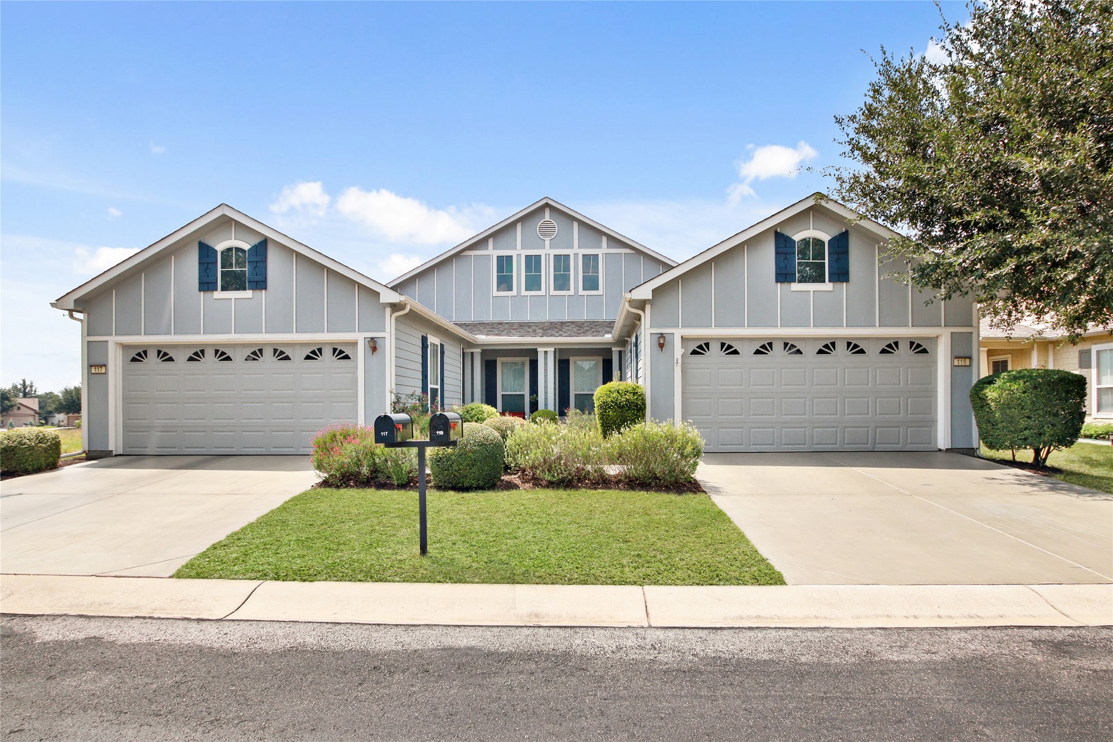 View of front of property with board and batten siding, driveway, and a front yard