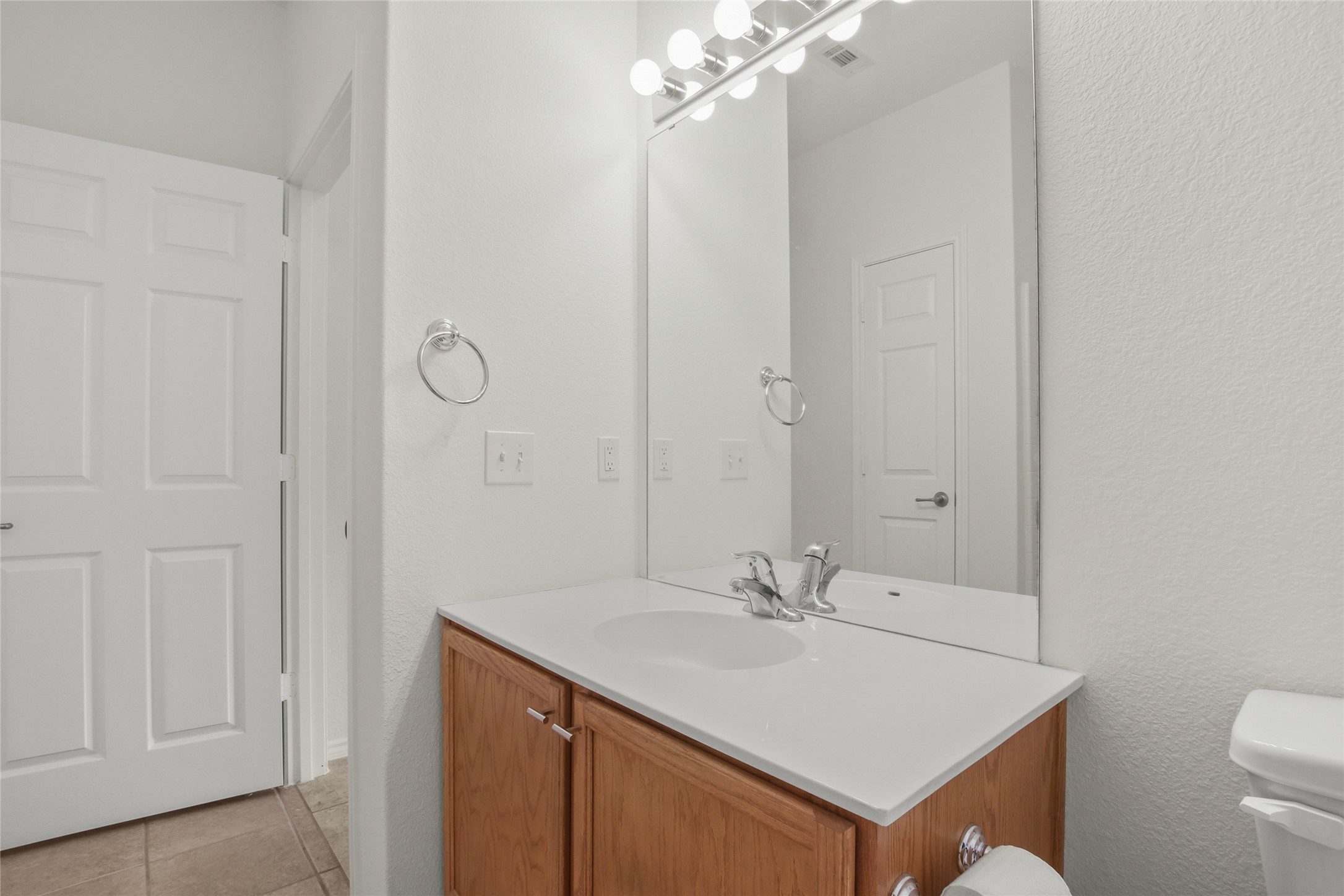 119 Hampton Circle Georgetown, TX 78633 - Photo 22 of 28 Half bath featuring vanity, light tile patterned flooring, and a textured wall