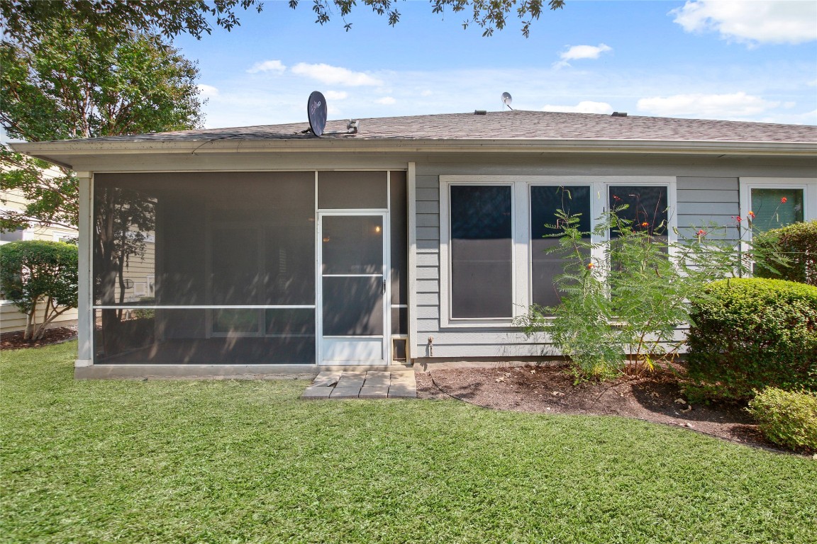 119 Hampton Circle Georgetown, TX 78633 - Photo 7 of 28 Rear view of house with a yard, a shingled roof, and a sunroom