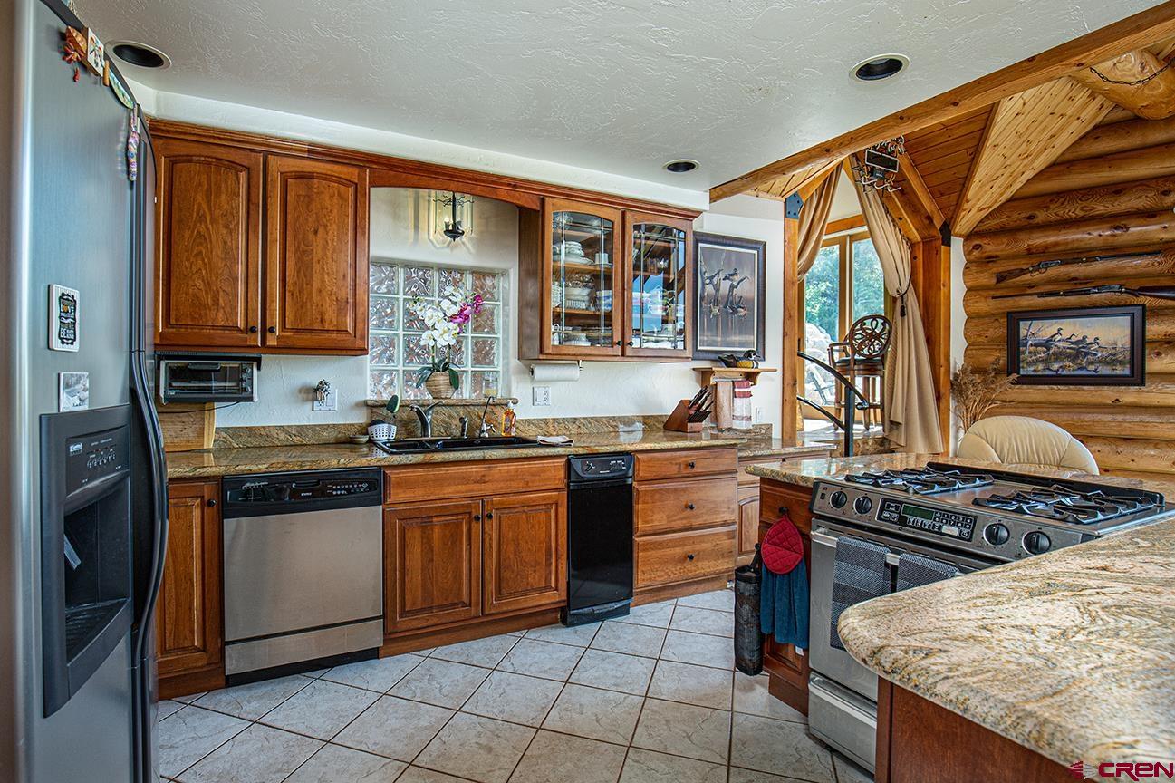 422 North Rainbow Road Durango, CO 81303 - Photo 19 of 34 a kitchen with stainless steel appliances granite countertop a stove a sink and a microwave