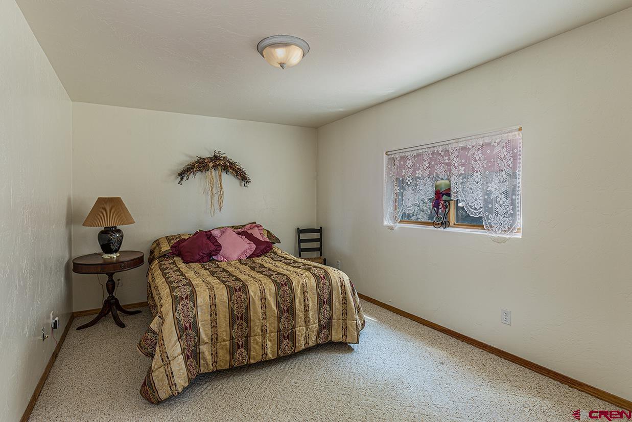 422 North Rainbow Road Durango, CO 81303 - Photo 28 of 34 a bedroom with a bed and chair