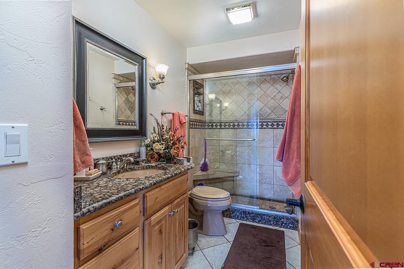 422 North Rainbow Road Durango, CO 81303 - Photo 30 of 34 a bathroom with a granite countertop sink toilet and shower