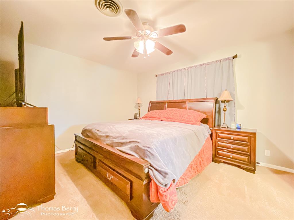 1104 Hickory Street Roscoe, TX 79545 - Photo 16 of 22 a bedroom with a bed and a chandelier